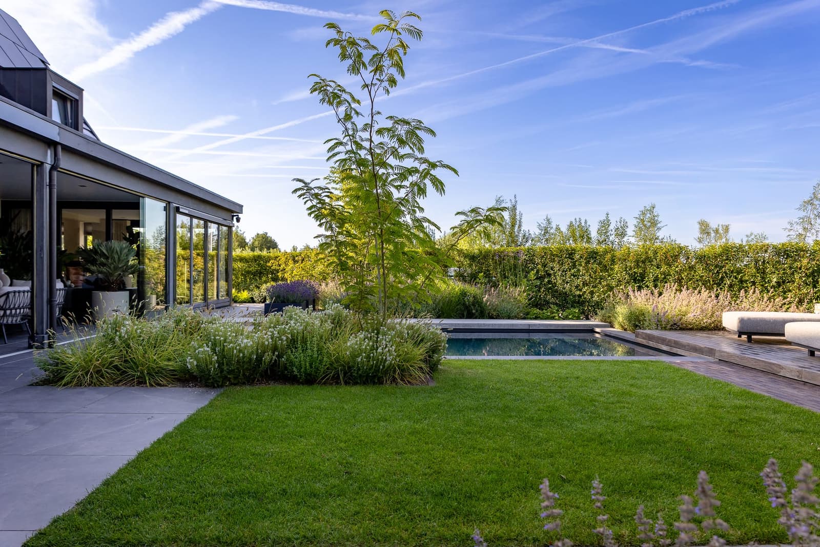 Aangelegde tuin met zwembad in Valburg door Van Rijbroek Hoveniers — foto 9 van 20